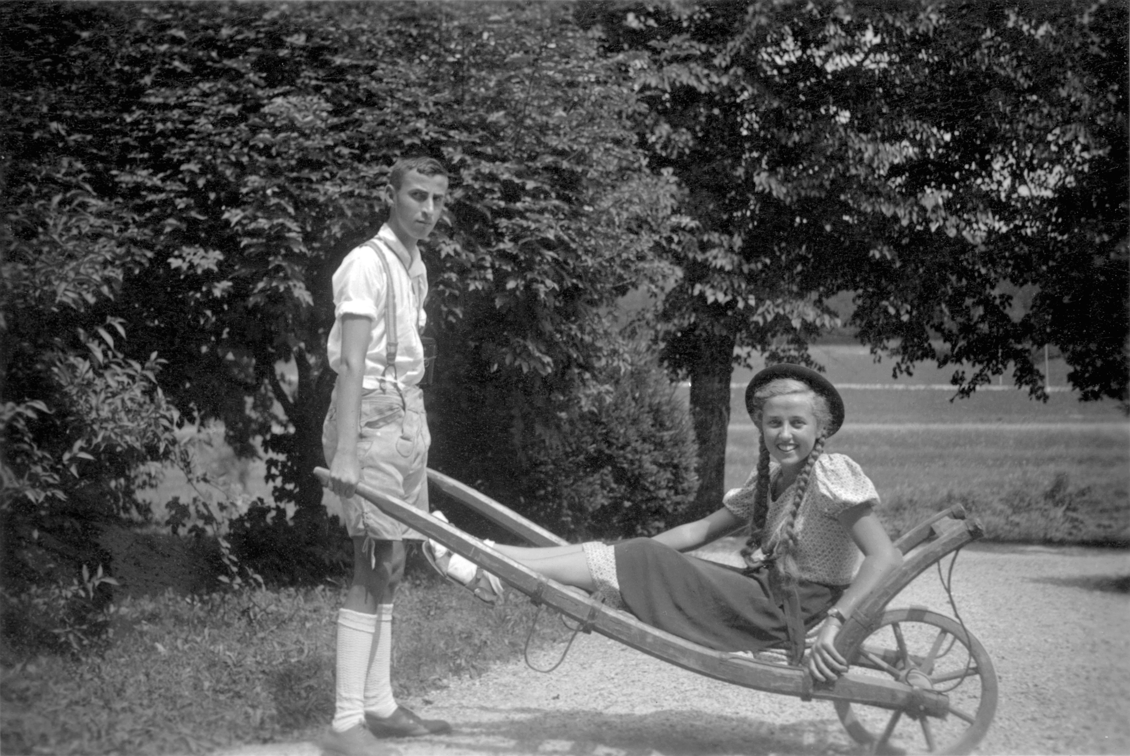 Junge schiebt sein Mdel in Schubkarre