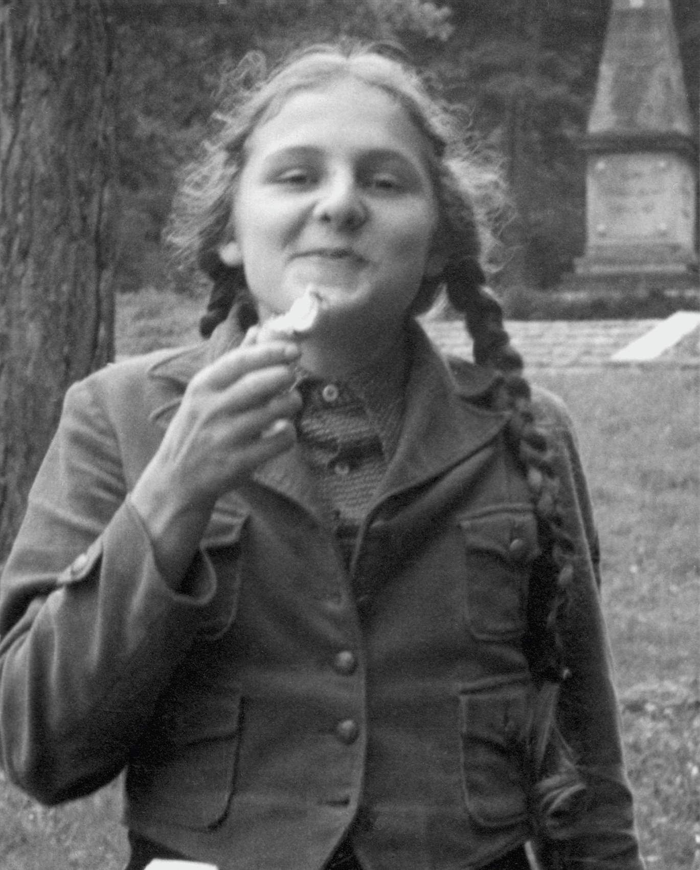 Essen einer Birne in Kletterweste vor Denkmal