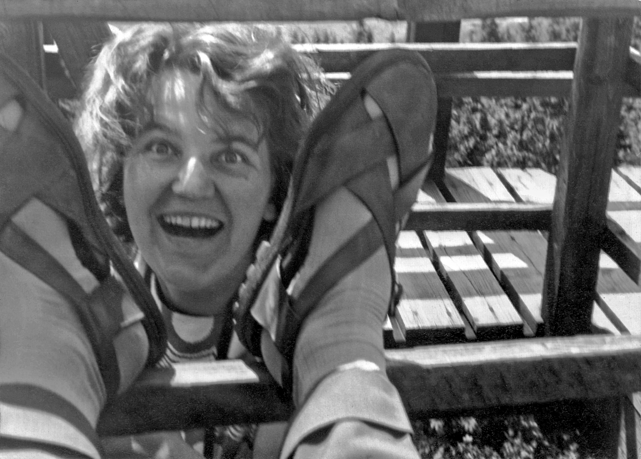 Kopf zwischen Sandalen und Holzgelaender